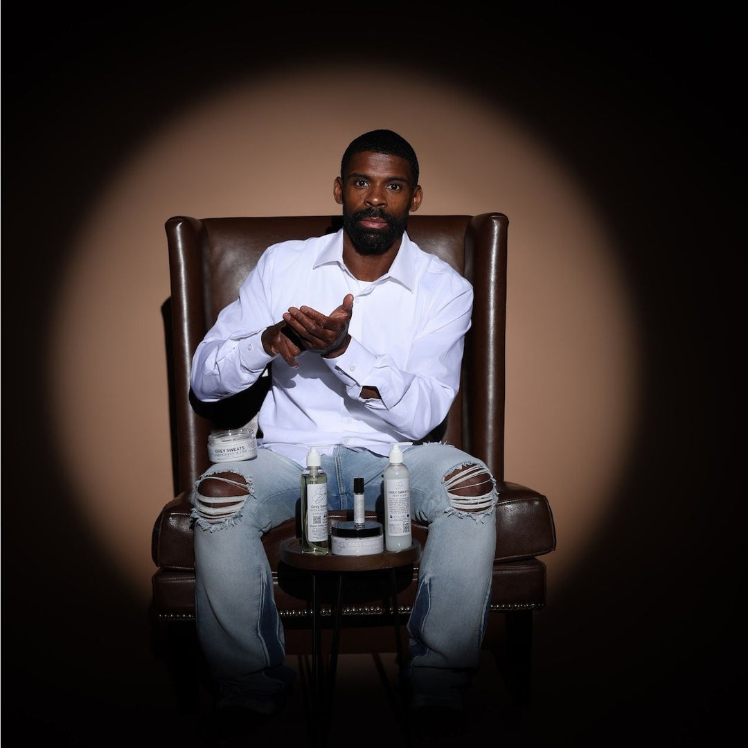 Man sitting in a leather chair with bottles on a dark background