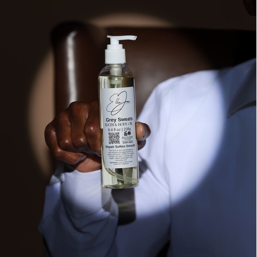 Person holding a bottle of Grey Sweatz hair product with a dark background