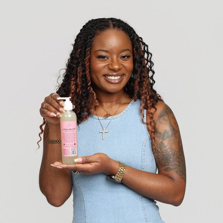 Woman holding a product against a plain background